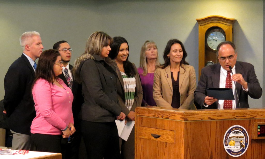 Yolo County Supervisor Jim Provenza presents a proclamation to a domestic violence survivor.