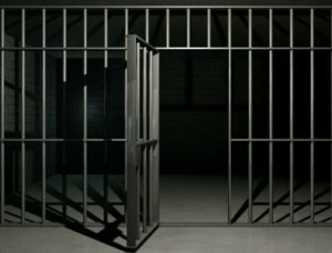 Image depicts an open jail cell door