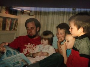 Image depicts murder victim, John O'Friel, reading a book to four of his seven children.