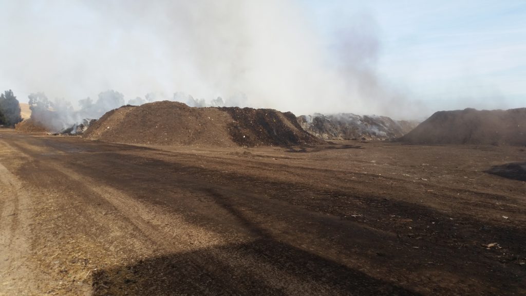 Image depicts compost piles that are on fire.