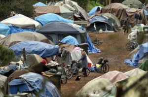 Image depicts a homeless encampment with multiple tents.