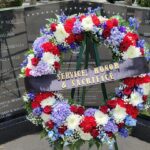 Image depicts the fallen peace officer memorial with a wreat made of red, white and blue flowers.