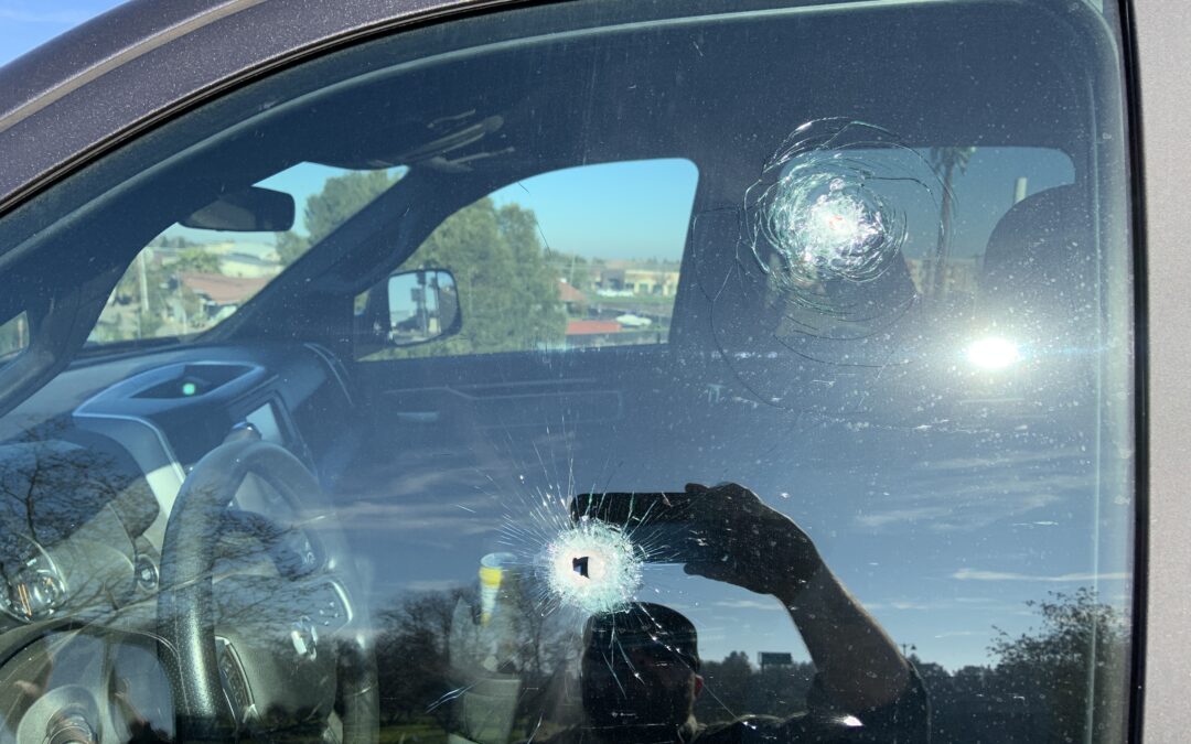 Image depicts one of the victims' vehicles with bullet holes in the window.